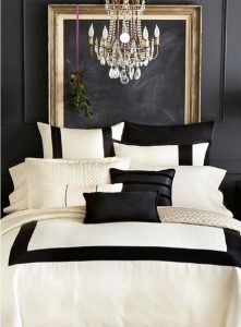 Elegant bedroom with gold decor, featuring a luxurious black and white decorated bed with stylish lighting