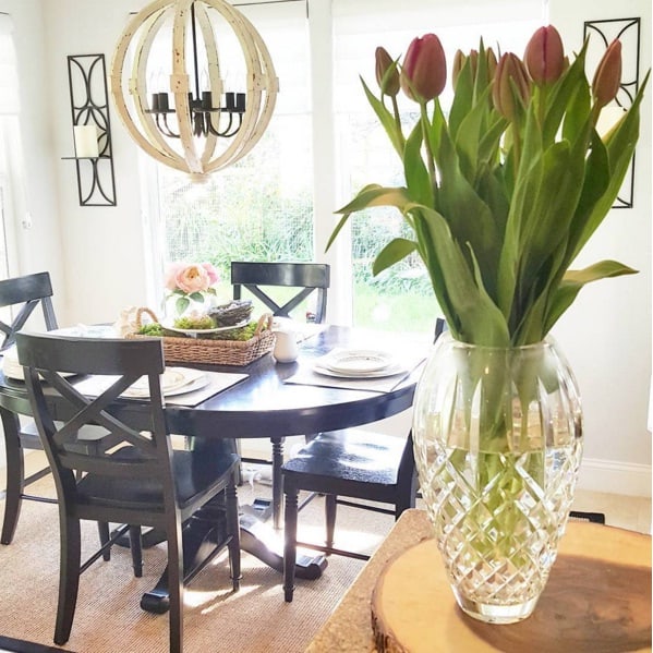spring-decor A bright and airy living room decorated with fresh pink tulips in a crystal vase on a wooden table, complemented by soft ivory walls and pastel accents for a fresh spring decor look.