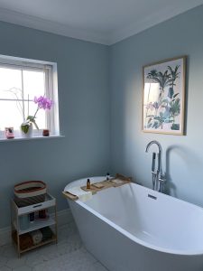 A modern bathroom featuring a luxurious freestanding bathtub, soft ambient lighting, and elegant décor for a relaxing spa-like atmosphere
