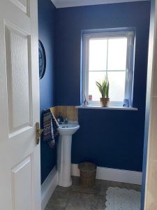A compact and stylish small bathroom with smart storage solutions, a glass shower, and light-coloured decor to enhance space