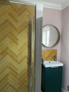 A modern bathroom featuring stylish patterned tiles, a sleek vanity, and elegant lighting, creating a sophisticated and refreshing space